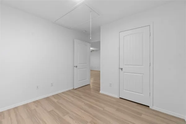 a view of an empty room and chandelier fan