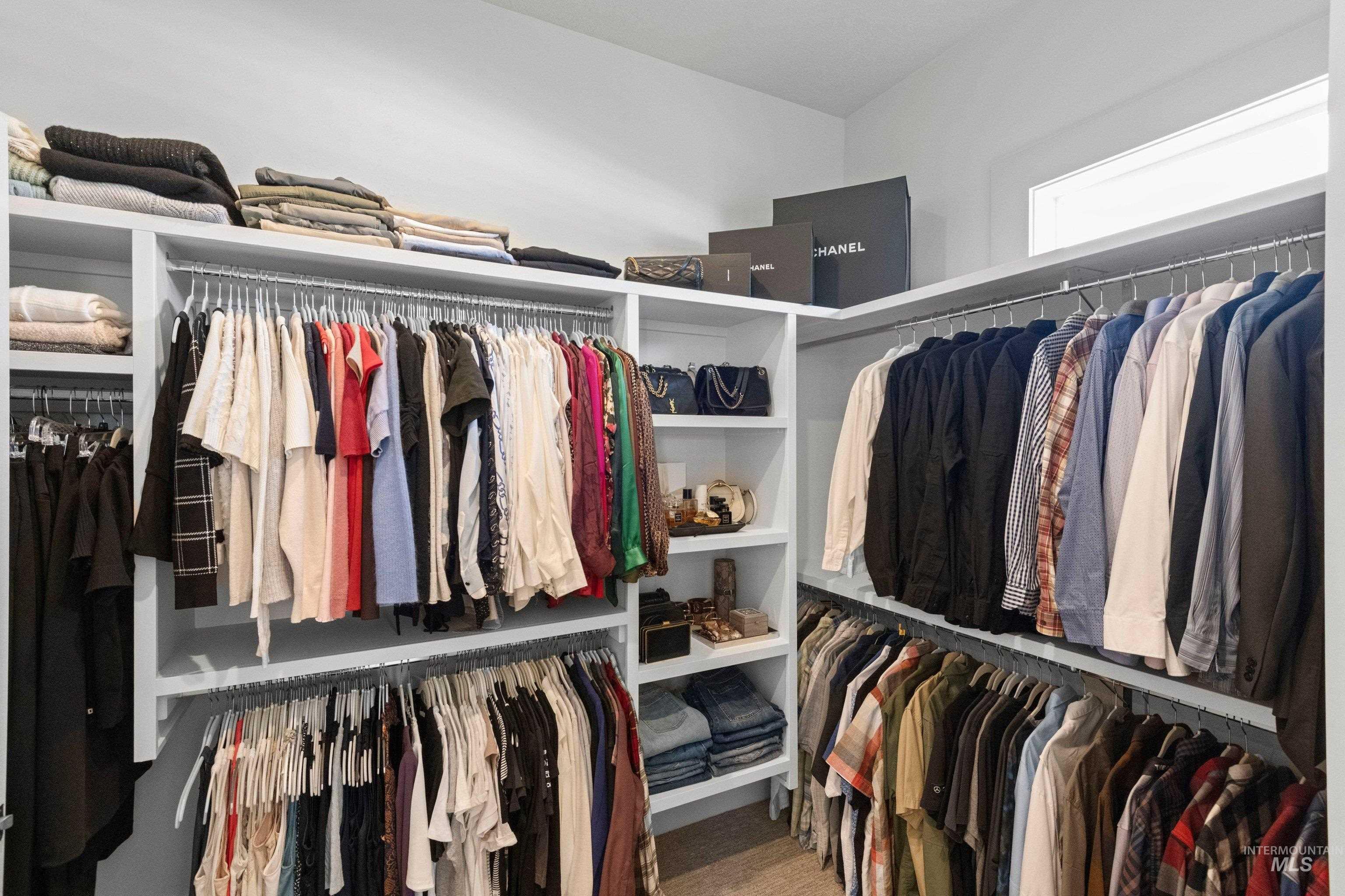 24990 Belgian Way Middleton, ID 83644 - Photo 27 of 50 Custom closet system featuring multiple hanging rods, integrated shelving units, a built-in corner shelf, and light wood-finish flooring