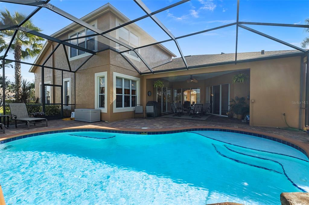 25745 Unbridled Court Wesley Chapel, FL 33544 - Photo 46 of 64 a view of a porch with a table and chairs under an umbrella