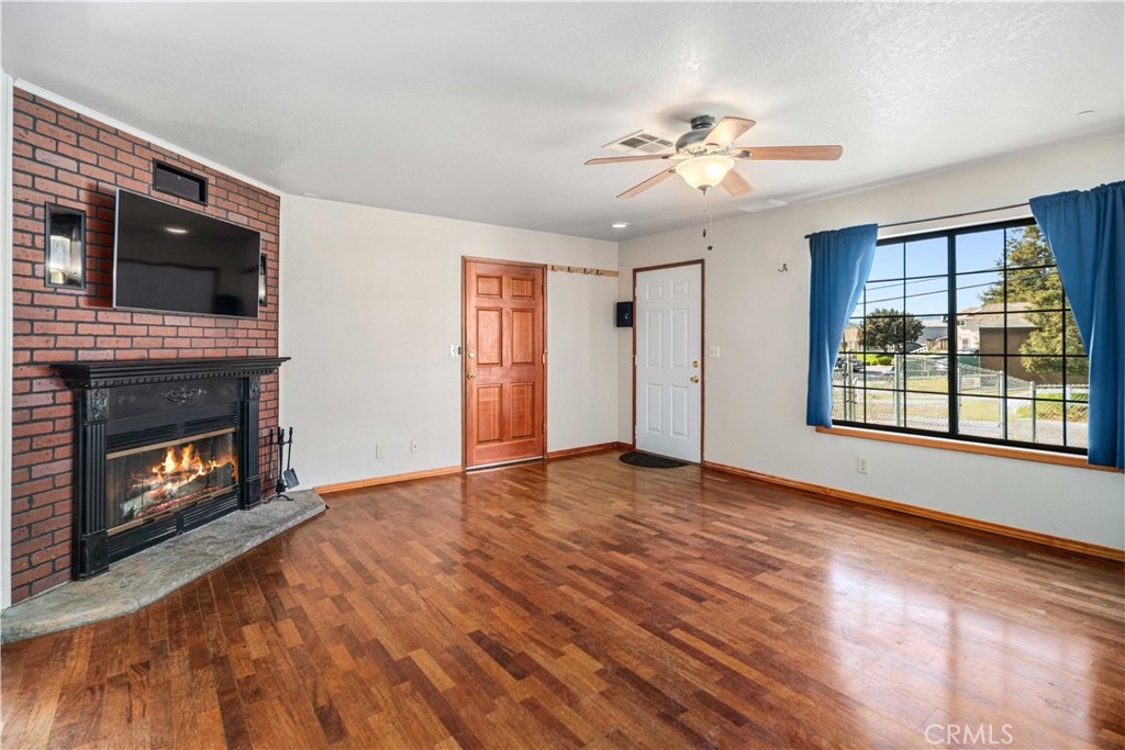 43230 Lookabout Road Lake Hughes, CA 93532 - Photo 5 of 40 a view of an empty room with wooden floor fireplace and a window