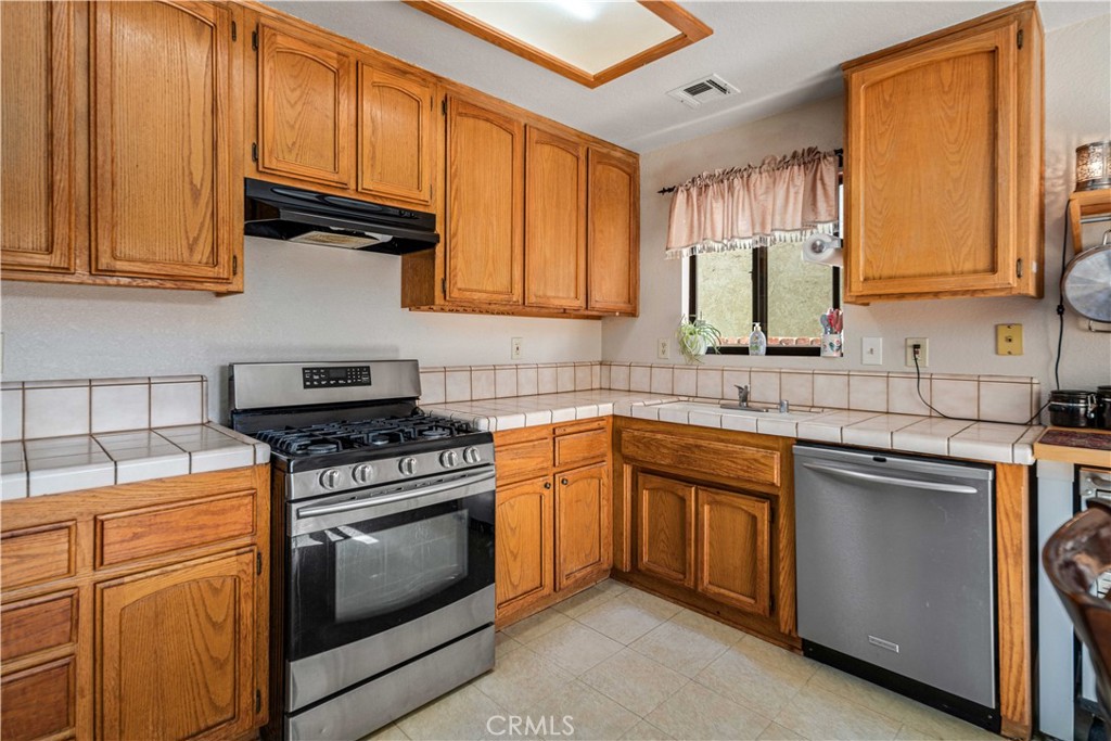 43230 Lookabout Road Lake Hughes, CA 93532 - Photo 8 of 40 a kitchen with stainless steel appliances granite countertop a stove sink and cabinets