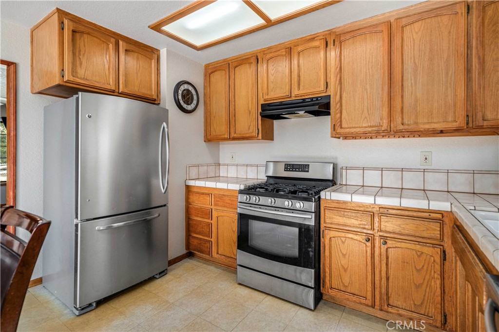 43230 Lookabout Road Lake Hughes, CA 93532 - Photo 10 of 40 a kitchen with stainless steel appliances granite countertop a refrigerator a stove and a sink