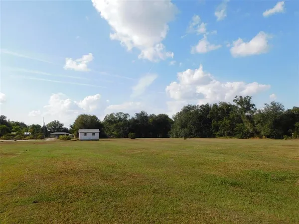 a view of yard with ocean and trees in the background