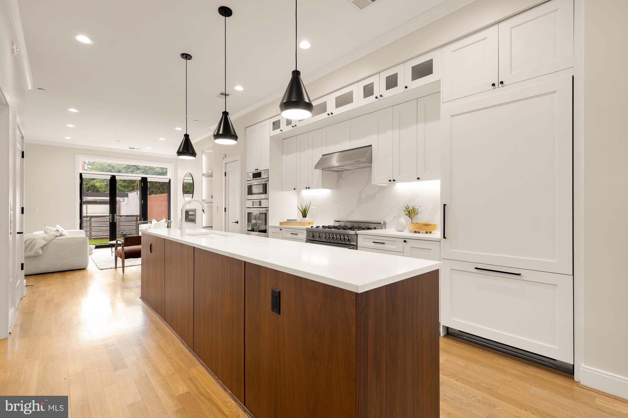 1311 D Street Southeast Washington, DC 20003 - Photo 11 of 57 a large kitchen with kitchen island a sink a center island stainless steel appliances and a counter top space