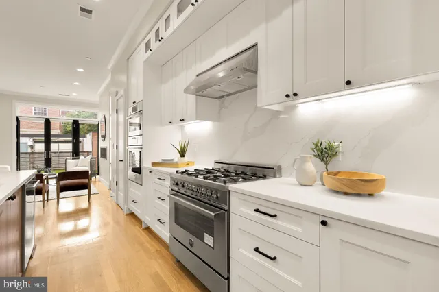 a large kitchen with stainless steel appliances kitchen island granite countertop a stove and a sink