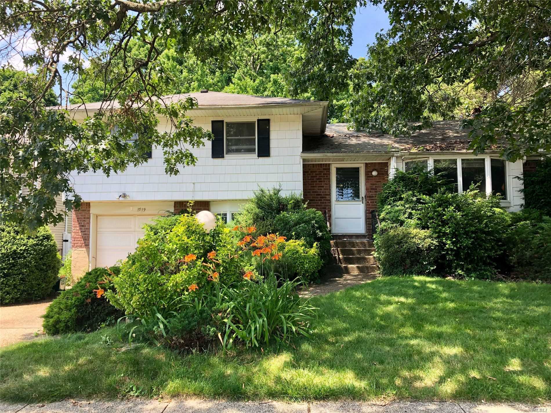 1719 Old Mill Road Merrick, NY 11566 - Photo 1 of 1 a front view of a house with garden