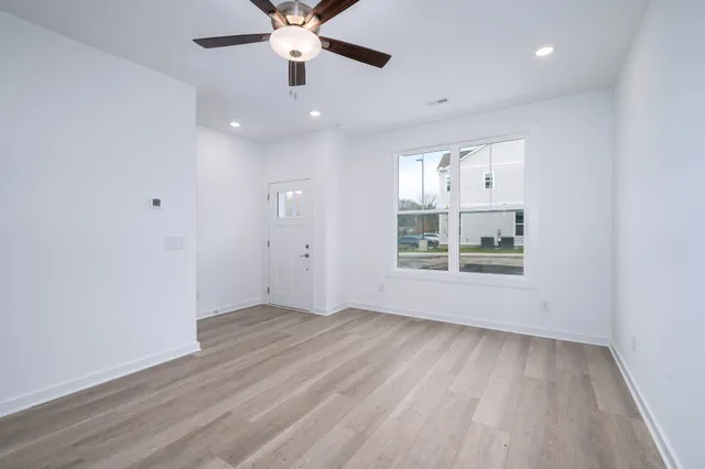 an empty room with wooden floor and windows