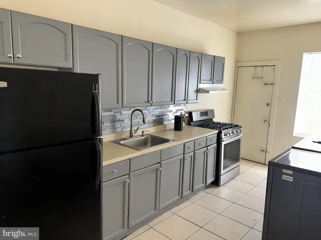 a kitchen with a sink a refrigerator and cabinets