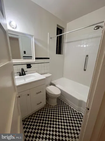 a bathroom with a sink a toilet a mirror and shower