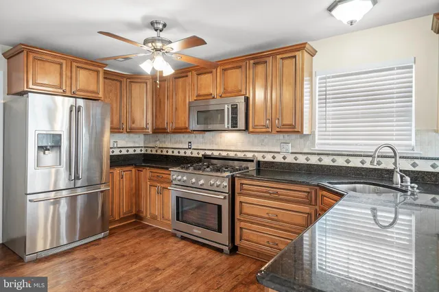 a kitchen with granite countertop stainless steel appliances and wooden cabinets