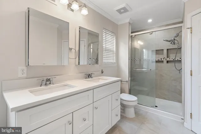 a bathroom with a bathtub a double vanity sink and mirror