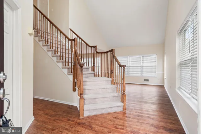 a view of staircase with wooden floor and a front door