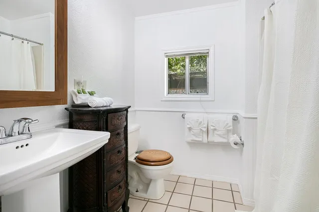 a bathroom with a sink toilet and mirror