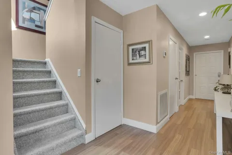 a view of a hallway with wooden floor and entryway