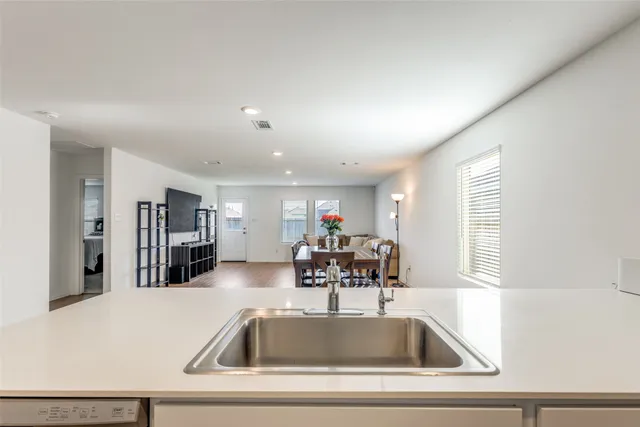 a view with kitchen island a sink wooden floor and a dining table chair