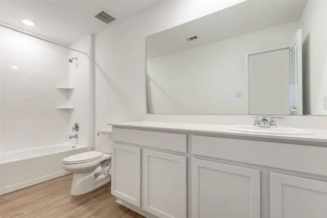 a bathroom with a sink a toilet and a large mirror