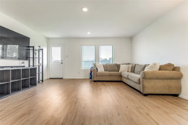 a living room with furniture and a wooden floor