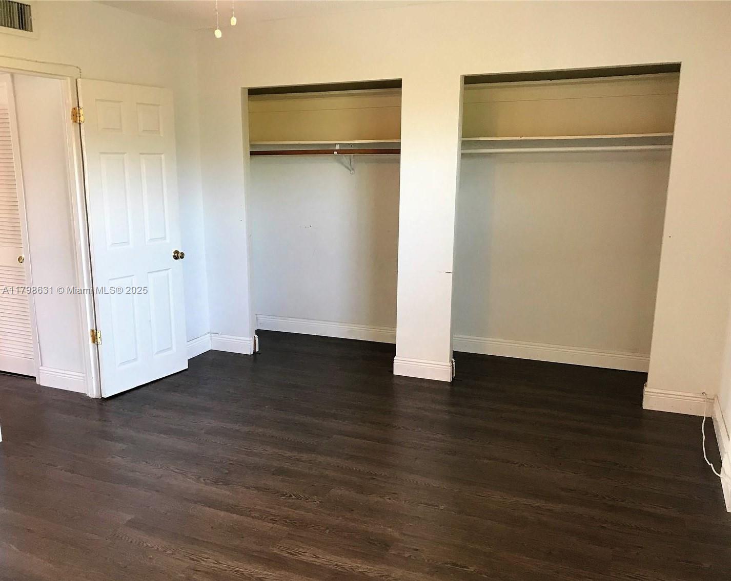 1100 Alton Road, Unit 3D Miami Beach, FL 33139 - Photo 12 of 14 a view of an empty room with wooden floor and a glass door