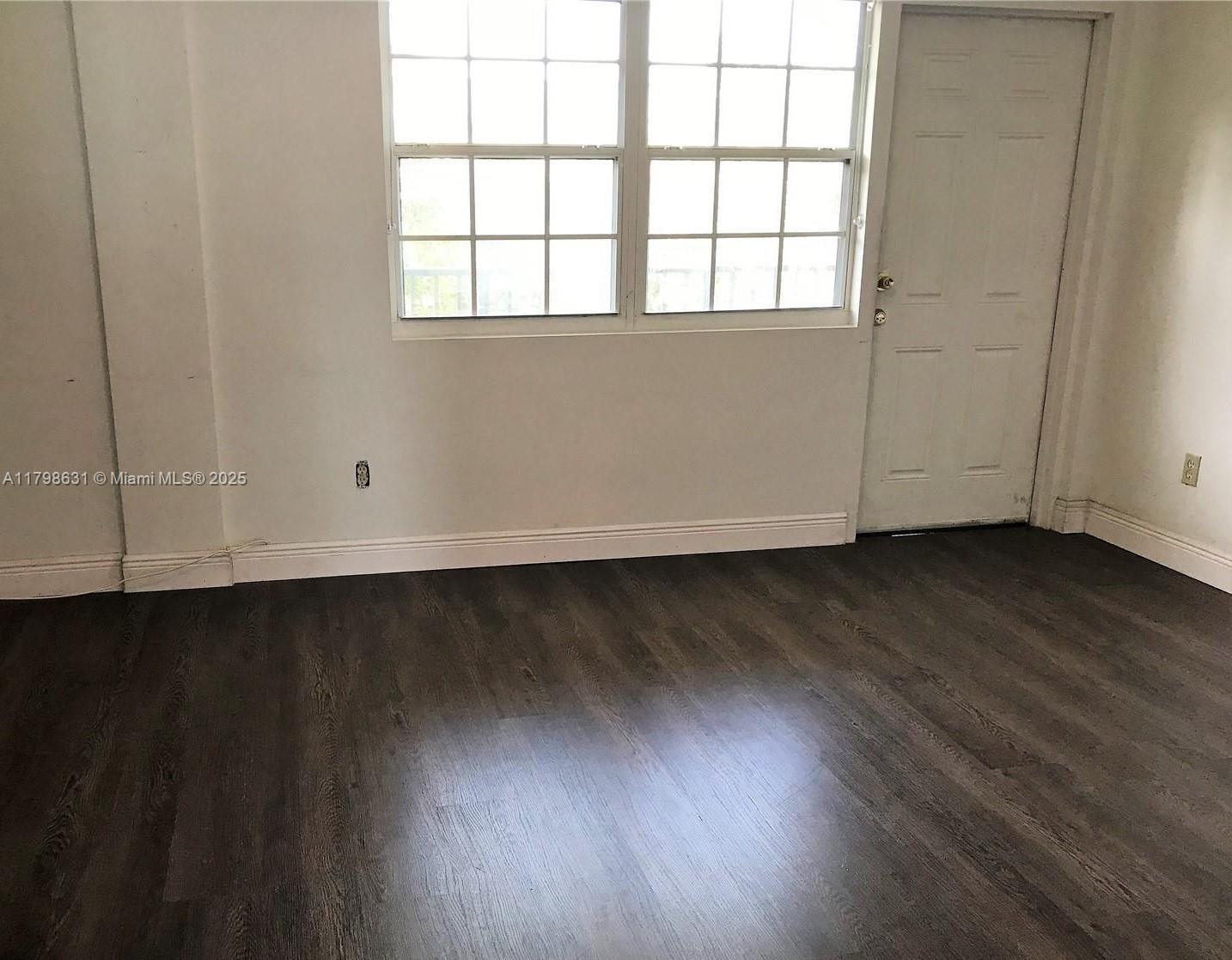 1100 Alton Road, Unit 3D Miami Beach, FL 33139 - Photo 5 of 14 an empty room with wooden floor and windows