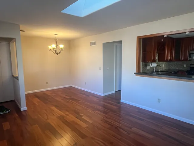 an empty room with wooden floor and a bathroom