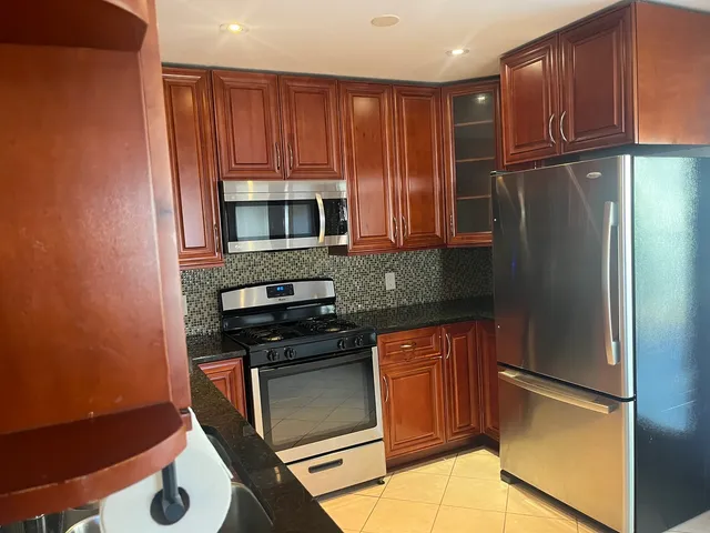 a kitchen with stainless steel appliances granite countertop a refrigerator stove and microwave