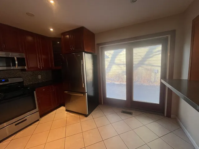 a kitchen with stainless steel appliances granite countertop a refrigerator and a sink
