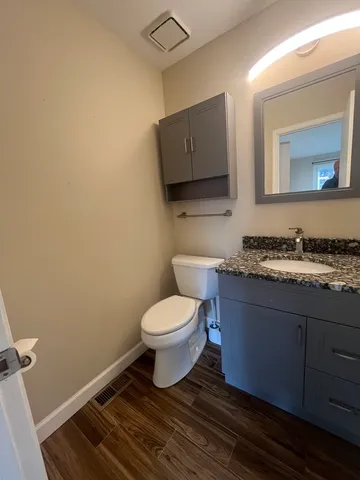 a bathroom with a toilet a sink and mirror