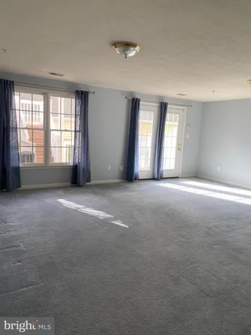 a view of a big room with windows and chandelier fan