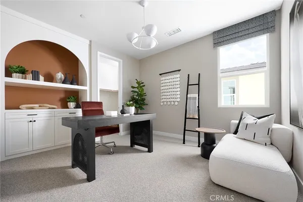 a living room with furniture a desk and a window