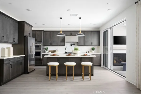 a kitchen with stainless steel appliances granite countertop a table chairs sink and cabinets