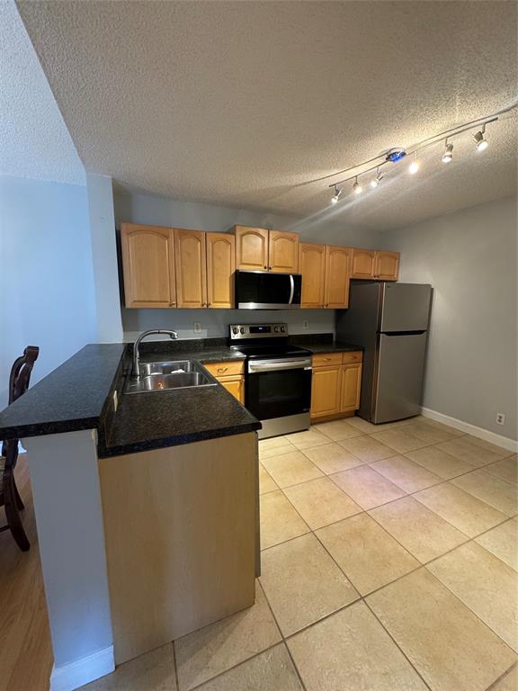 5681 Riverside Drive, Unit 203 Pompano Beach, FL 33067 - Photo 3 of 14 a kitchen with stainless steel appliances granite countertop a stove a sink and a microwave