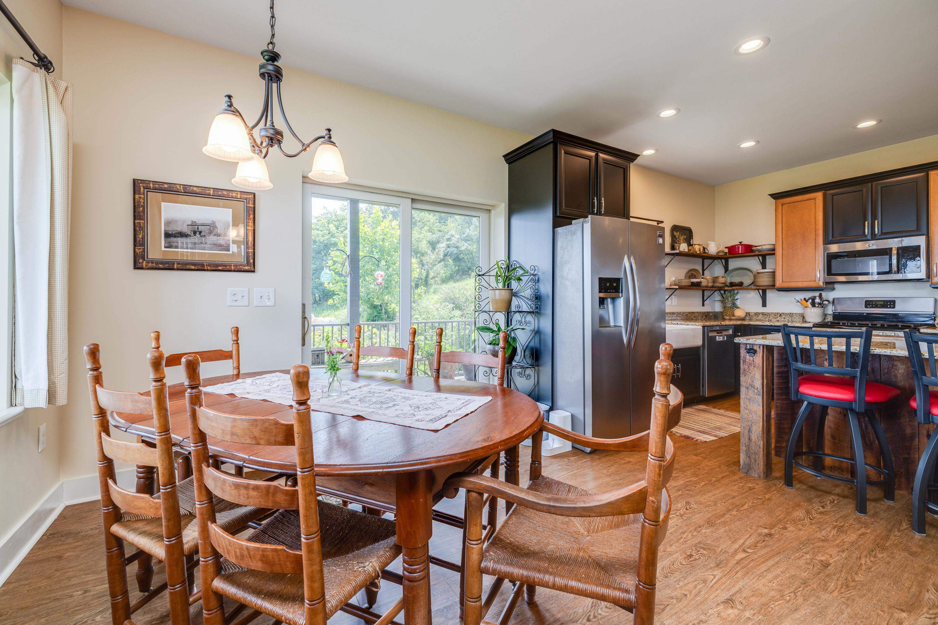 11180 Daphna Road Broadway, VA 22815 - Photo 14 of 75 Directly off the kitchen is a large dining area. This space features a chandelier, hardwood flooring, windows overlooking a view of the mountains, and plenty of space for a table and chairs set.