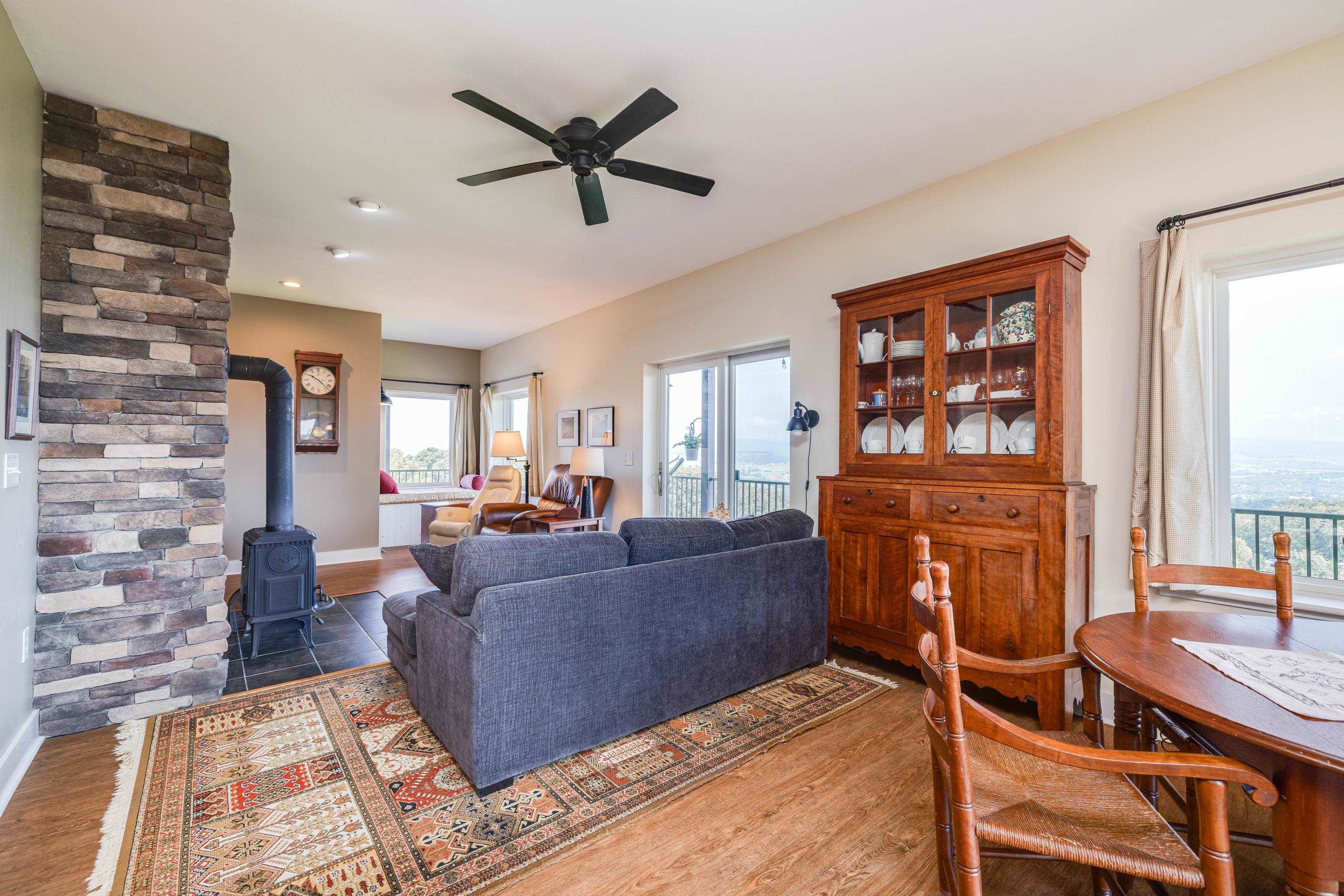11180 Daphna Road Broadway, VA 22815 - Photo 17 of 75 The large living room features expansive windows overlooking the front porch and the beautiful front yard views the home offers. This space contains a wood stove, hardwood flooring, ceiling fan, and lots of space for gathering with family and friends.