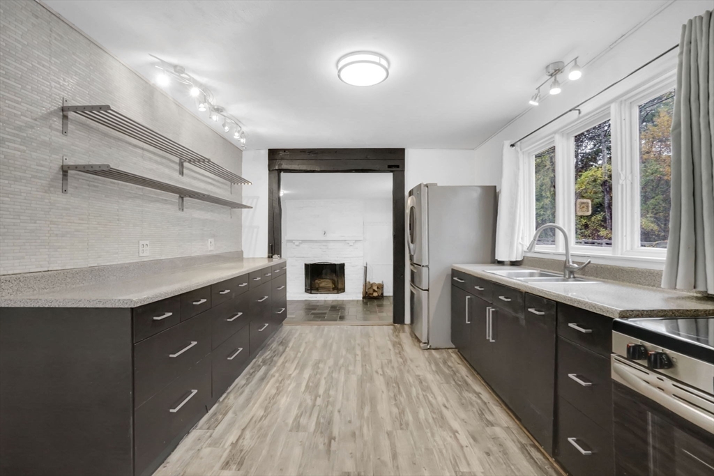 20 Pomeroy Meadow Road Easthampton, MA 01027 - Photo 13 of 42 a large kitchen with granite countertop a stove top oven a sink dishwasher a dining table and chairs with wooden floor