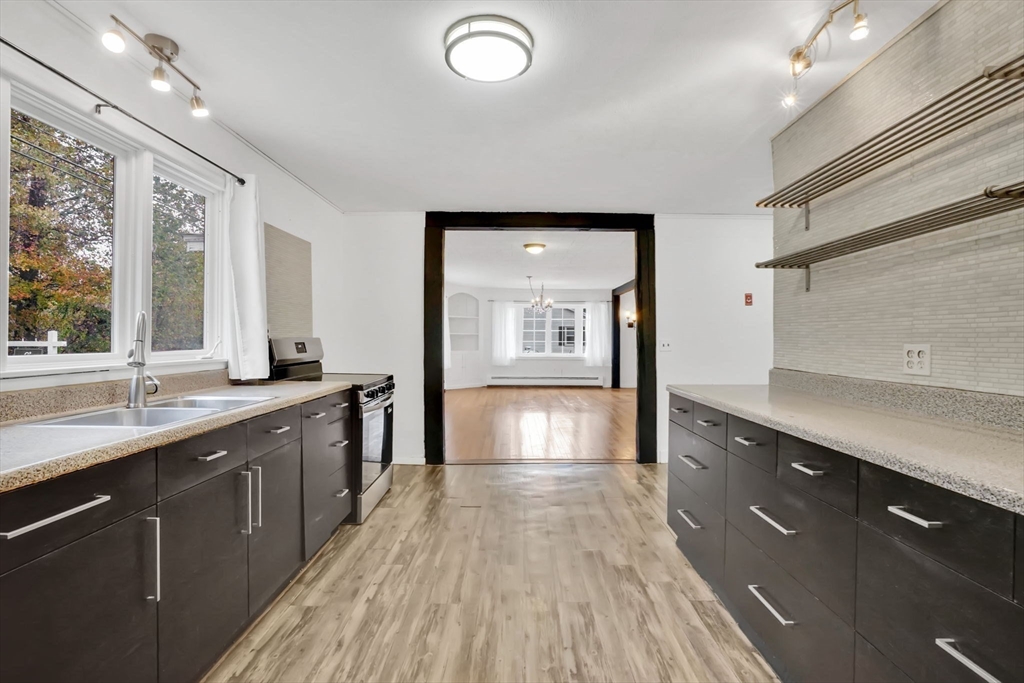 20 Pomeroy Meadow Road Easthampton, MA 01027 - Photo 9 of 42 a large kitchen with stainless steel appliances a large counter top a sink dishwasher and a large window with wooden floor