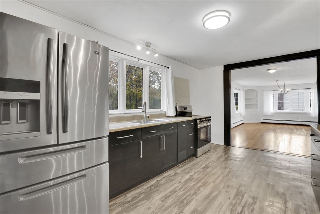 20 Pomeroy Meadow Road Easthampton, MA 01027 - Photo 10 of 42 a kitchen with stainless steel appliances granite countertop a refrigerator a sink dishwasher a stove and white countertops with wooden floor