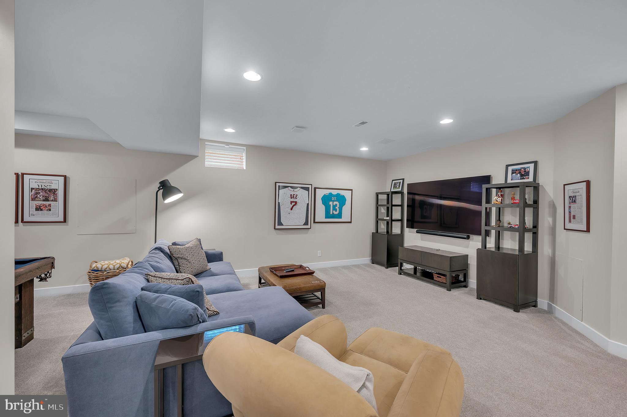 421 Howard Road Gladwyne, PA 19035 - Photo 40 of 49 a living room with furniture a refrigerator and a flat screen tv