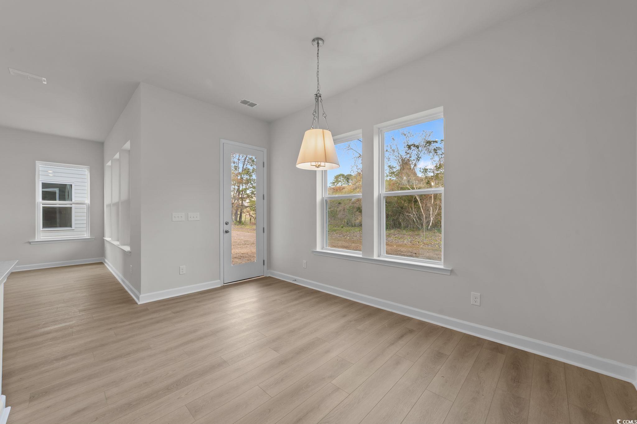 787 Ebb Tide Road Little River, SC 29566 - Photo 13 of 32 Unfurnished dining area featuring baseboards and light wood-style floors