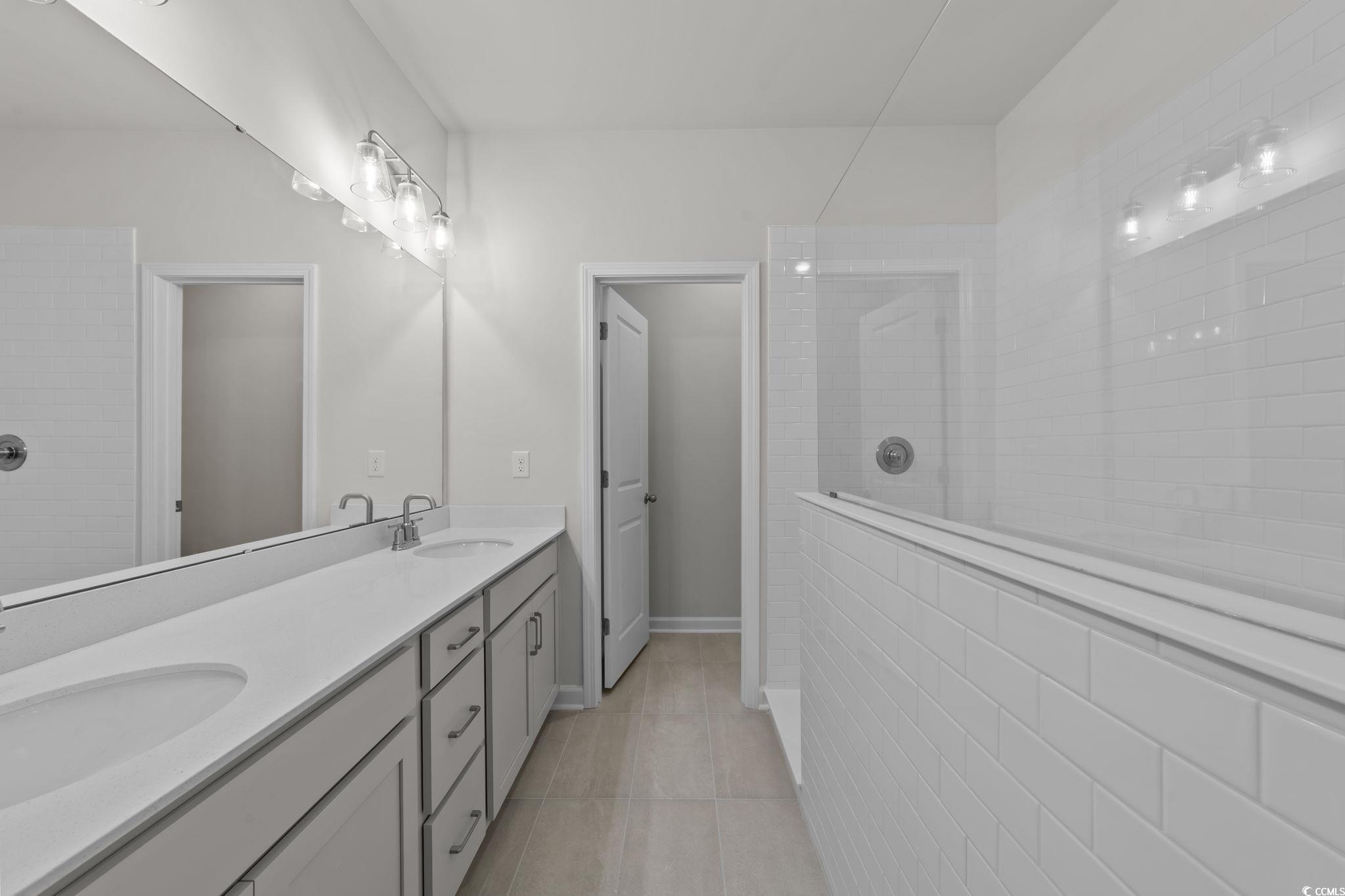 787 Ebb Tide Road Little River, SC 29566 - Photo 19 of 32 Full bath with a walk in shower, double vanity, and light tile patterned flooring