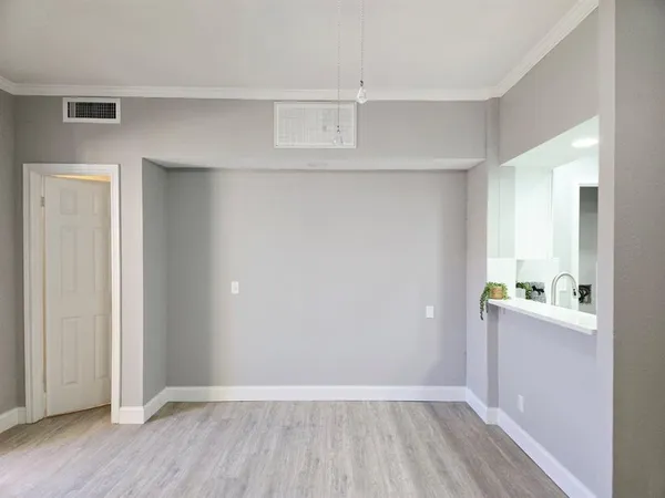 an empty room with wooden floor and cabinet