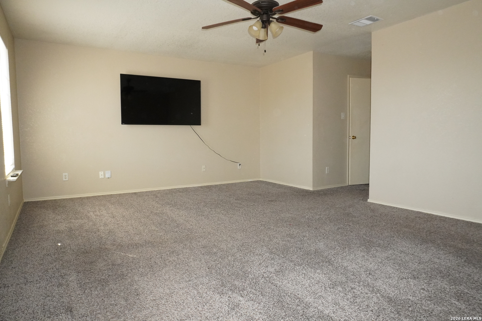 8162 Heights Valley Converse, TX 78109 - Photo 10 of 18 a view of a livingroom with a flat screen tv and a ceiling fan