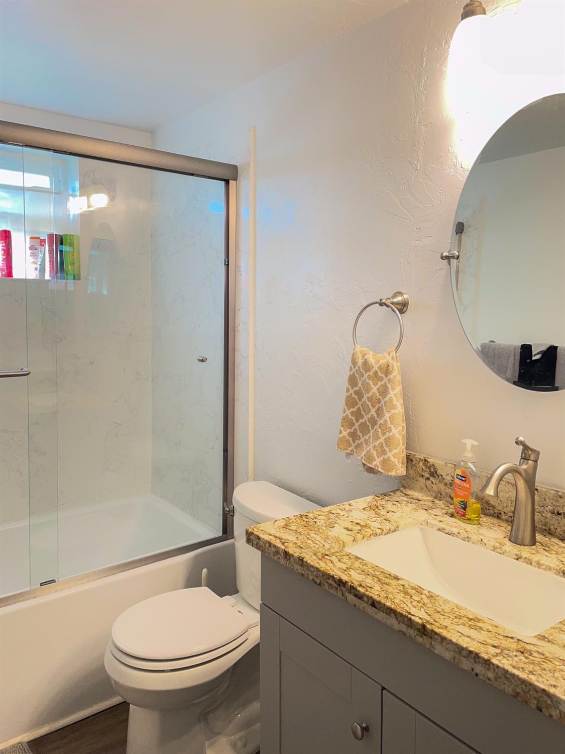 414 F Street Isleton, CA 95641 - Photo 41 of 49 a bathroom with a granite countertop sink toilet and shower