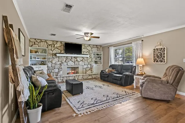 a living room with furniture a flat screen tv and a fireplace