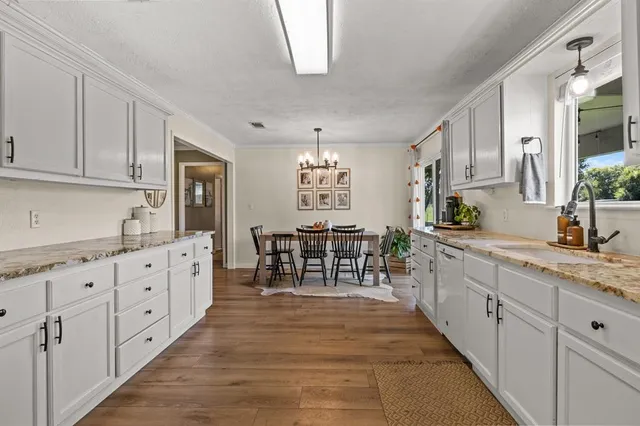a large white kitchen with cabinets