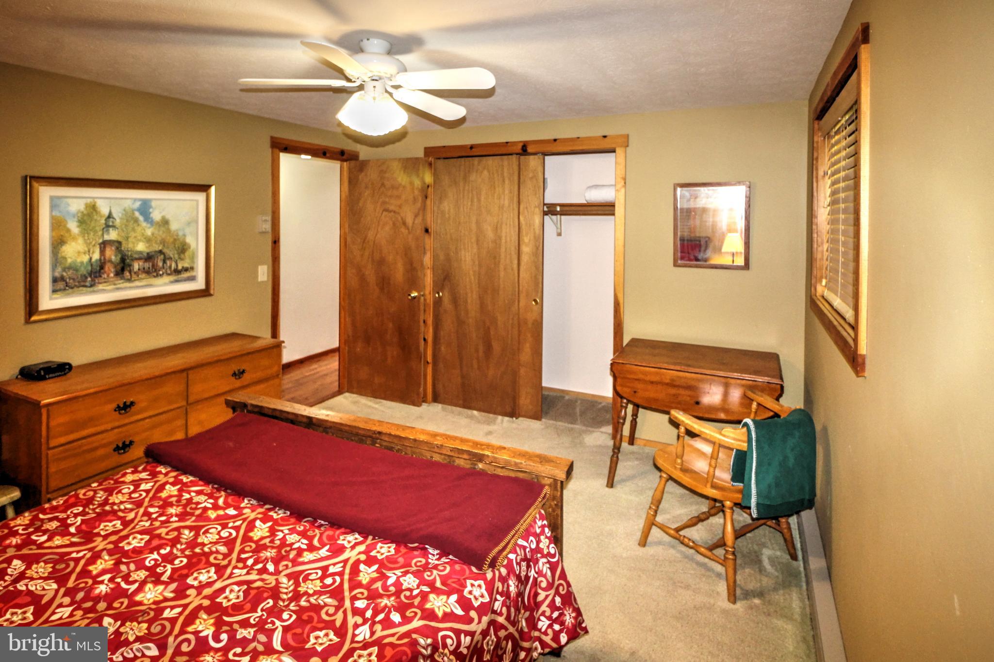 198 Hood's Point Road Basye, VA 22810 - Photo 14 of 23 a bedroom with a bed and a chandelier