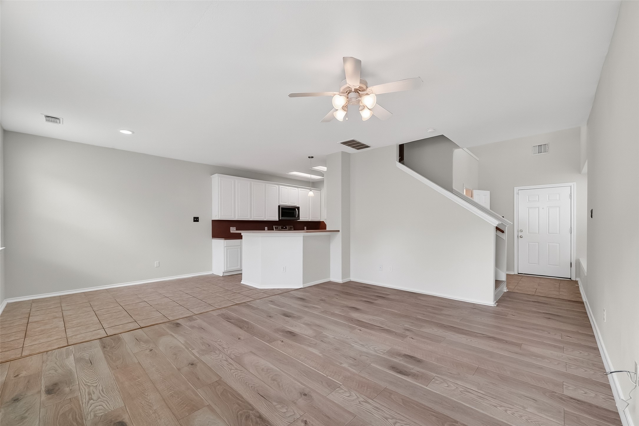 16623 Newglen Lane Houston, TX 77084 - Photo 7 of 33 a view of a kitchen with wooden floor and a ceiling fan