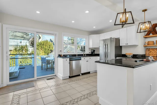 a kitchen with stainless steel appliances kitchen island granite countertop a refrigerator and a stove top oven