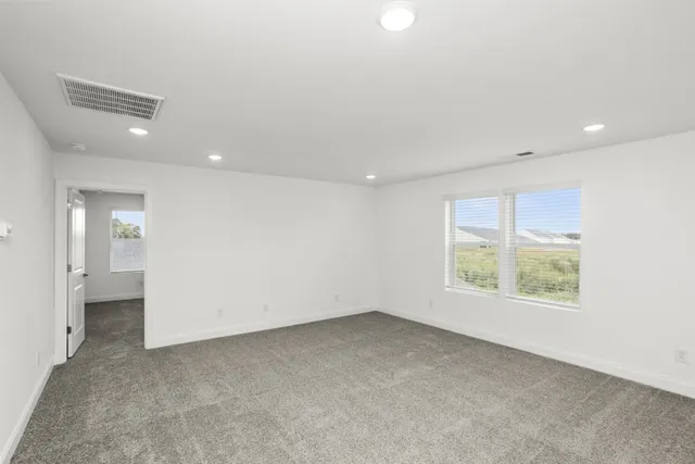 an empty room with windows and bathroom