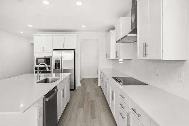 a kitchen with kitchen island granite countertop a sink a counter top space stainless steel appliances and cabinets