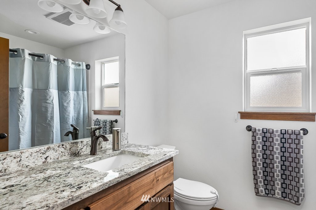 1471 North View Road Oak Harbor, WA 98277 - Photo 25 of 38 a bathroom with a granite countertop sink toilet and mirror
